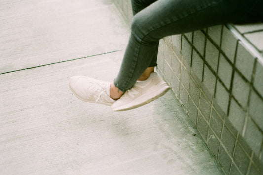 person in blue denim jeans and white sneakers
