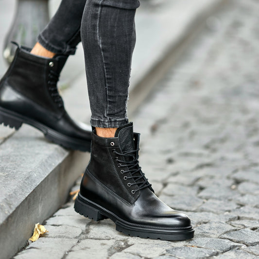 a person standing on a sidewalk wearing black boots