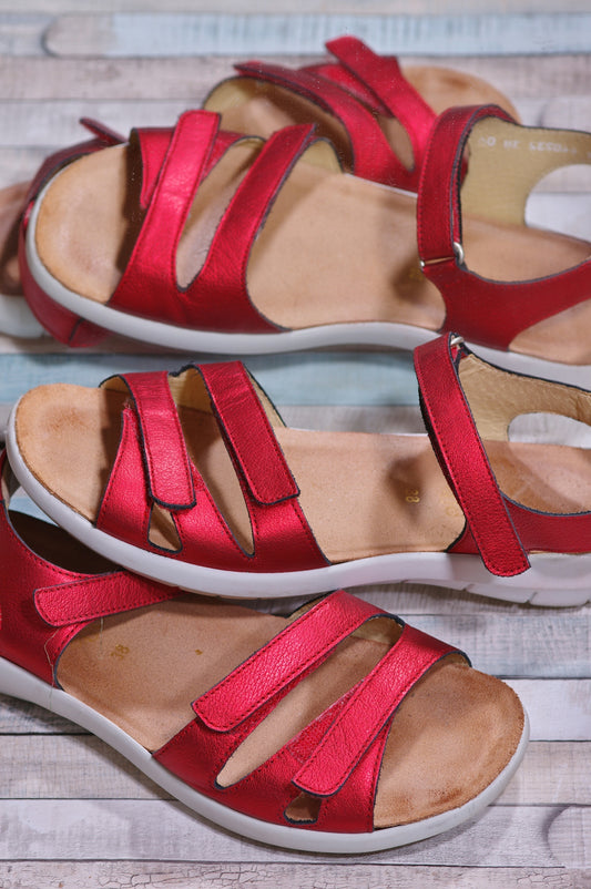 a pair of red shoes sitting on top of a wooden floor