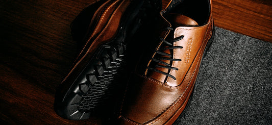 a pair of brown shoes sitting on top of a wooden floor