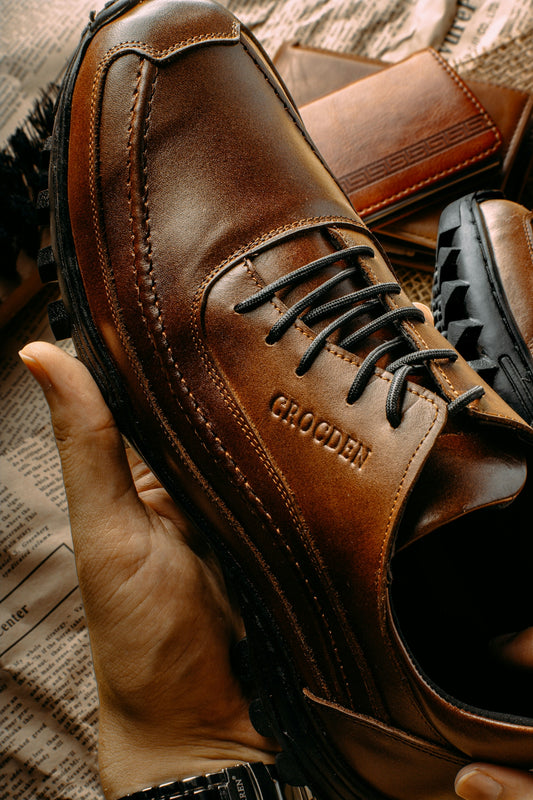 a person holding a pair of brown shoes