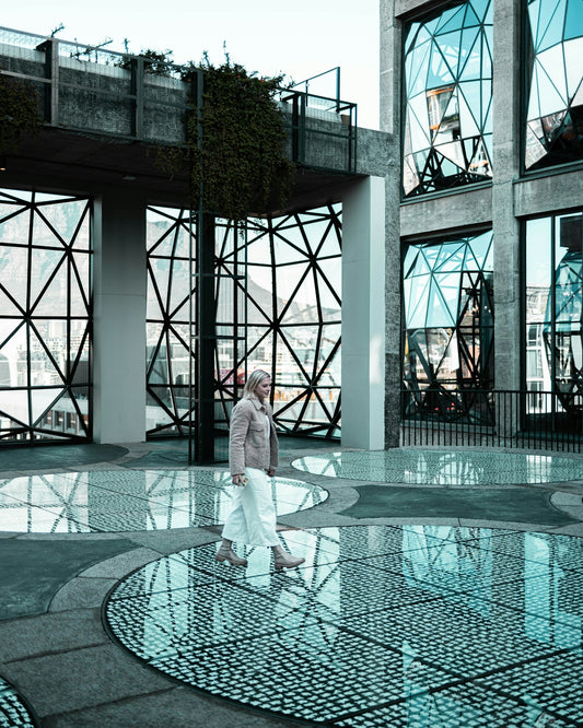 a person standing in front of a glass building
