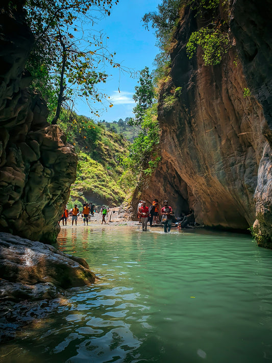 a group of people walking along a river