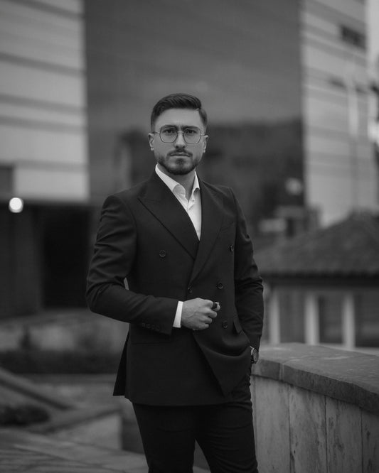A man in a suit standing on a sidewalk