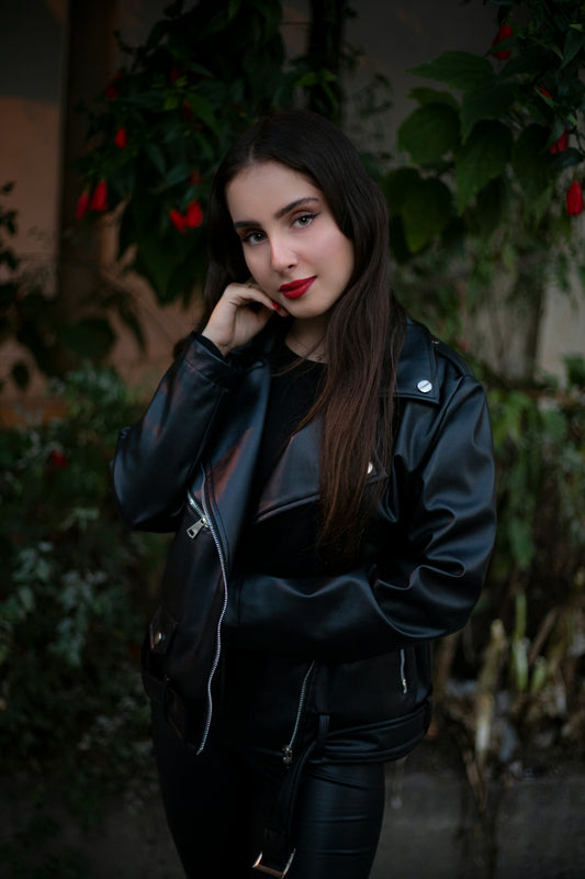 A woman in a black leather jacket posing for a picture