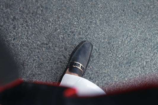 A person wearing a pair of black shoes