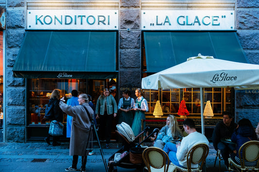 A group of people sitting at tables outside of a restaurant