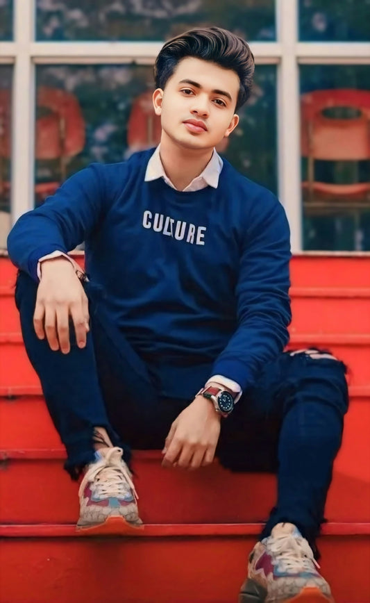A young man sitting on top of a red step
