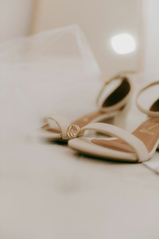 Wedding rings rest on elegant bridal heels