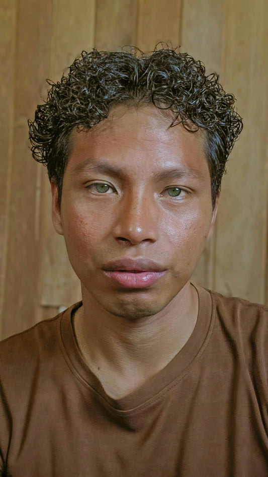 A man with curly hair stares at the camera.
