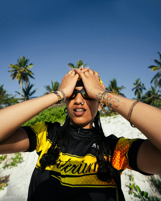 Woman with hands over eyes on a sunny beach.